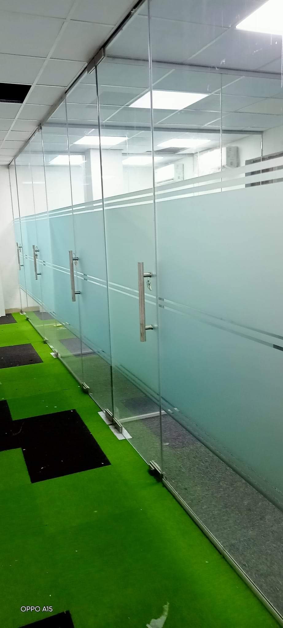 Long glass partition with frosted band and door handles